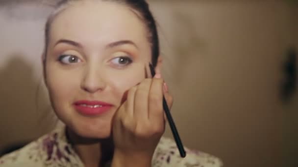 Красивая девушка делает макияж — стоковое видео