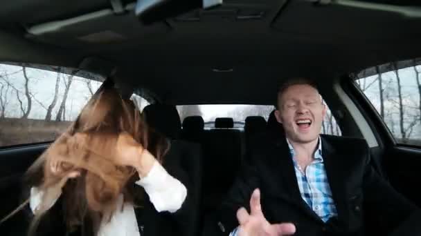 O menino e a menina em estilo de negócios dançando no carro — Vídeo de Stock