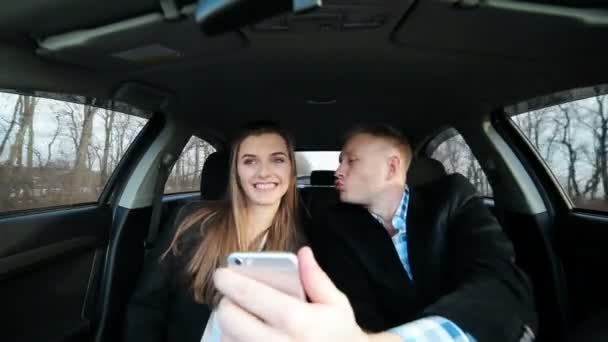 Jóvenes amantes de la pareja hermosa utilizando el teléfono en el viaje en coche — Vídeos de Stock