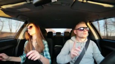 Güzel çift arabada günbatımında dans