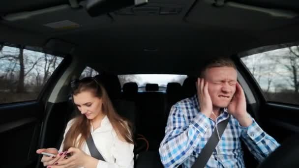 La chica trabaja con el teléfono, el tipo en el coche escuchando música — Vídeos de Stock