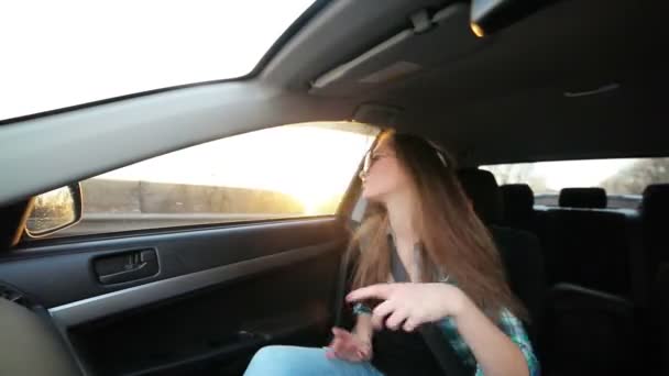 Mooi meisje dansen in de auto, zonsondergang — Stockvideo