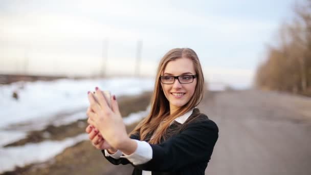 女の子が何を得意のスマート フォンのカメラを正面向きを使用して selfie — ストック動画