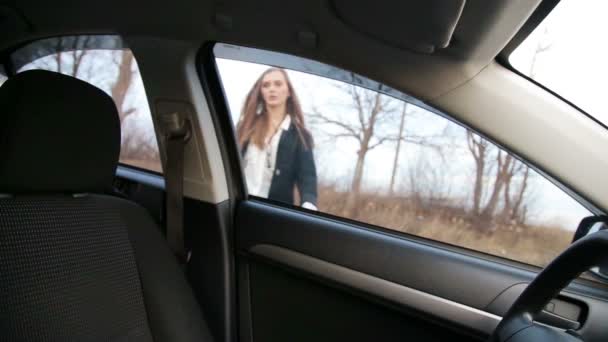 Elegant woman putting on safety belt in her car — Stock Video