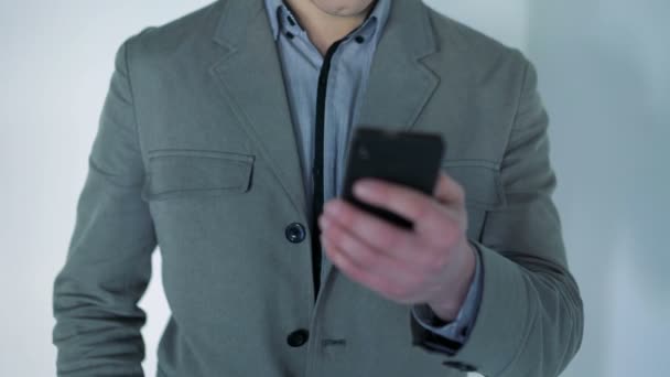 Hombre alegre sosteniendo el teléfono móvil y sonriendo — Vídeos de Stock