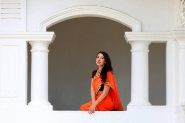 Turuncu Sari Giyen Şık Hintli Kadın Beyaz Mimari Ayarlarda Pozisyon