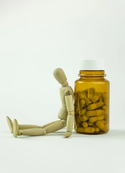 Wooden doll and pills — Stock Photo, Image