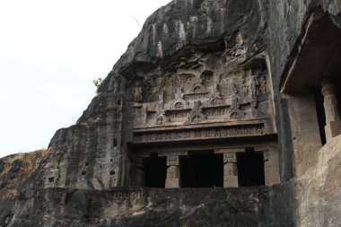23 Ekim 2025; Ellora Mağaraları, Maharashtra, Hindistan: Büyük taş kesimli bir mağara tapınağının etkileyici cephesi, girişi büyük taş sütunlardan oluşan bir sütunla işaretlenmiştir. Islak.