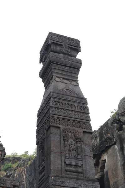 23 Ekim 2025; Ellora Mağaraları, Maharashtra, Hindistan: Düşük açılı bir görünüm Kailasa Tapınağı 'nın (16. Mağara) görkemli, monolitik taş sütunu (Dhwajastambha) yakalar, bulutlu gökyüzüne karşı onun karmaşık oymalarını vurgular..