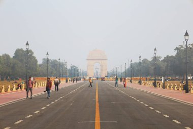 Delhi, Hindistan, 28 Kasım 2025: Hindistan Kapısı Anıtı 'na giden Kartavya Yolu' nun geniş açılı manzarası yoğun sis ve sisle kaplı ve uzaklardan gelen turistlerle dolu.