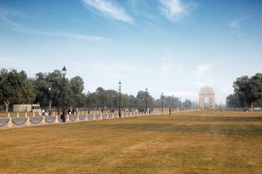 Delhi, Hindistan, 28 Kasım 2025: Güneşli bir kış gününde mavi gökyüzünün altında Hindistan Kapısı Anıtı 'na uzanan Central Vista çimlerinin ve Kartavya Yolu' nun geniş açılı manzarası.