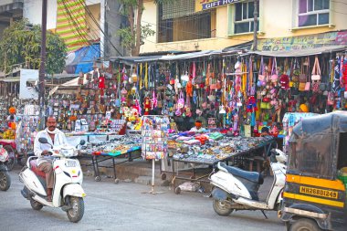 Nanded, MH, Hindistan, 21 Aralık 2025: Güneşli bir günde Gurudwara pazarı yakınlarında renkli çantalar, hediyeler ve aksesuarlar satan yol kenarı dükkanları.