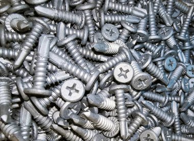 Çelikten yapılmış pek çok metal vida var, metal için kendi kendine vurabilen vida, demir için kendi kendine vurabilen vida, krom kaplama kendi kendine vurabilen vida, arka plan olarak dağınık vidalar.