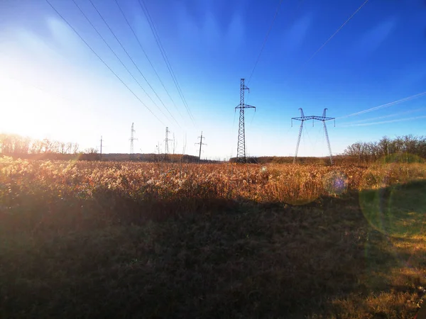 Electric transmission line. Power transmission pylon silhouette against blue sky at dusk. The concept of electrification