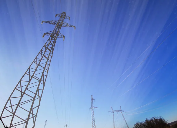 Electric transmission line. Power transmission pylon silhouette against blue sky at dusk. The concept of electrification