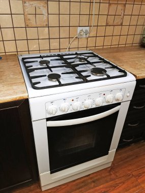 Modern bir mutfağın içinde, beyaz bir gaz sobasıyla yakın plan fırın..