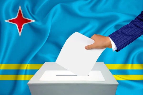 투표함에서 투표하는 남자의 투표용지를 넣습니다 플래그 아루바가 배경에 — 스톡 사진
