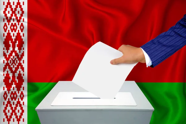 国内の選挙 投票箱で投票する 男の手が投票箱に投票する ベラルーシの国旗を背景に — ストック写真