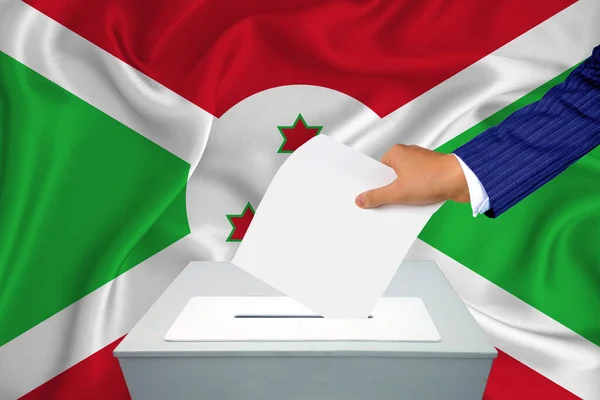 国内の選挙 投票箱で投票する 男の手が投票箱に投票する 背景に旗ブルンジ — ストック写真