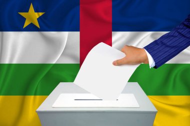 Ülkedeki seçimler - oy sandığında oy kullanma. Bir adam oyunu sandığa koyuyor. Arka planda Orta Afrika Cumhuriyeti Bayrağı.