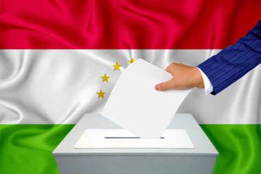 Ülkedeki seçimler - oy sandığında oy kullanma. Bir adam oyunu sandığa koyuyor. Arkaplanda Tacikistan bayrağı.