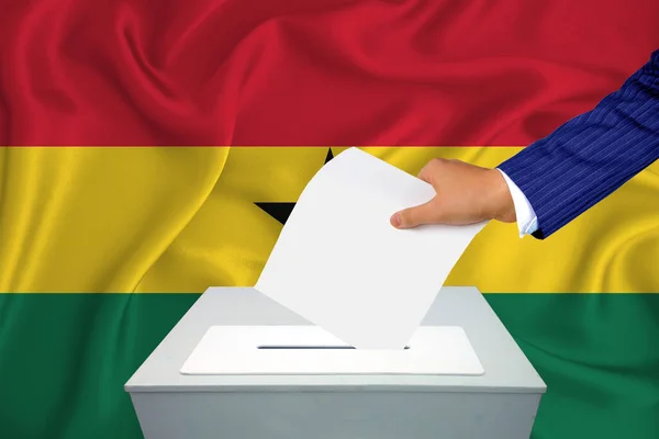 国内の選挙 投票箱で投票する 男の手が投票箱に投票する ガーナ国旗を背景に — ストック写真