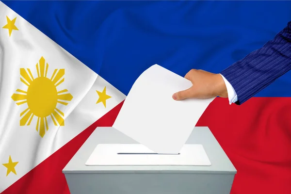 国内の選挙 投票箱で投票する 男の手が投票箱に投票する 背景に旗フィリピン — ストック写真
