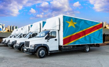 Beş yeni beyaz kamyonun arkasındaki Kongo bayrağı nehrin ve şehrin arka planına karşı. Kamyon, nakliye, nakliye. Yük ve Lojistik Konsepti