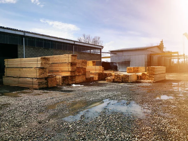 Wood warehouse. Lumber logs, boards and beams basic building material. Industrial plant sawmill - storage of wooden boards