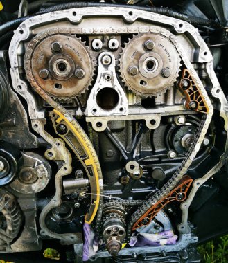 Tamir sırasında parçalanmış araba motoru. Motor zincirinin patlamış görüntüsü, tamir ve onarım sırasında dişliler ve gerilim aletleri. Araba servisi..