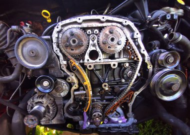 Tamir sırasında parçalanmış araba motoru. Motor zincirinin patlamış görüntüsü, tamir ve onarım sırasında dişliler ve gerilim aletleri. Araba servisi..