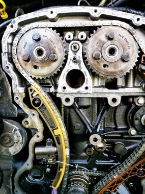 Tamir sırasında parçalanmış araba motoru. Motor zincirinin patlamış görüntüsü, tamir ve onarım sırasında dişliler ve gerilim aletleri. Araba servisi..