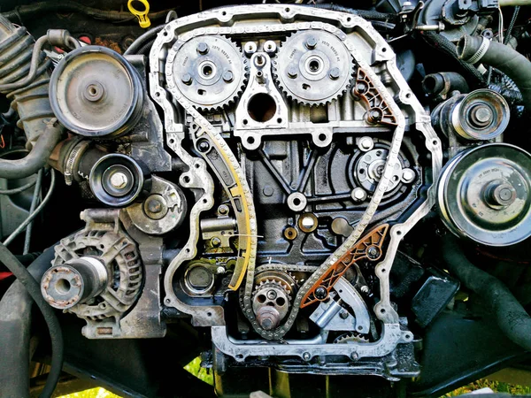 Tamir sırasında parçalanmış araba motoru. Motor zincirinin patlamış görüntüsü, tamir ve onarım sırasında dişliler ve gerilim aletleri. Araba servisi..