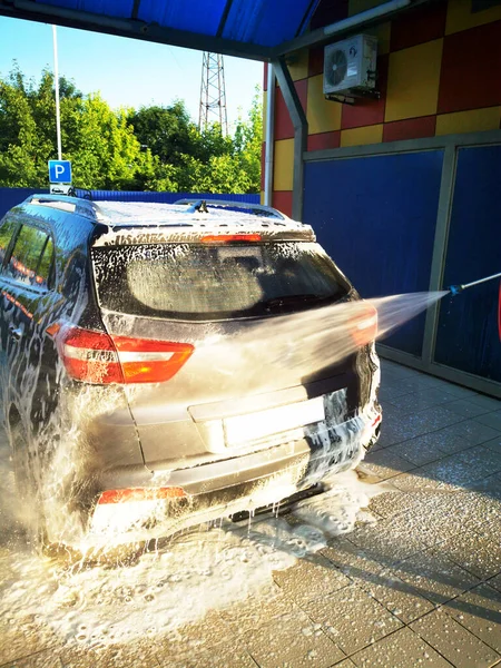 車の中で若い男が高圧下で車を洗う 選択的焦点 — ストック写真