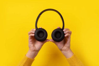 Sarı arka planda siyah kulaklıklar.