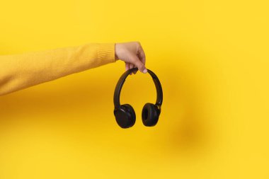 Sarı arka planda siyah kulaklıklar.