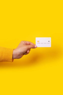 Elinde boş beyaz kart, sarı arka planda elektronik çip var.