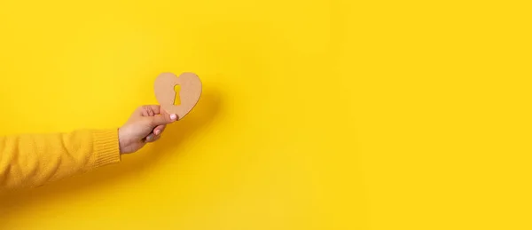 Coração Madeira Com Fechadura Mão Sobre Fundo Amarelo — Fotografia de Stock