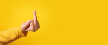 fuck hand sign over yellow background