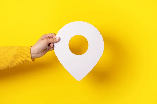 黄色の背景に手に3D位置シンボル — ストック写真
