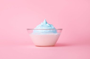 Pembe arka planda bir kase krema.