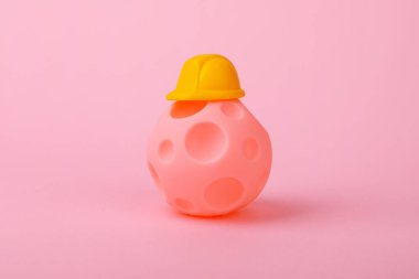 Pembe arka planda miğferi olan gezegen. Bilinmeyen gezegenlerin yerleşimi kavramı.