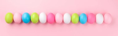 Pembe arka planda renkli Paskalya yumurtaları, panoramik görüntü