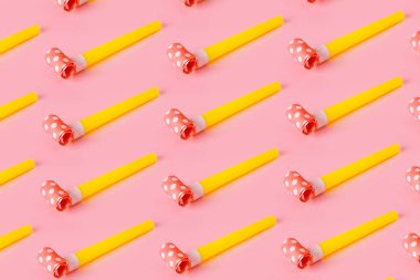 Pembe arka planda doğum günü partisi ıslıkları, parti kornalarıyla renkli kutlama şablonları, asgari parti konsepti.