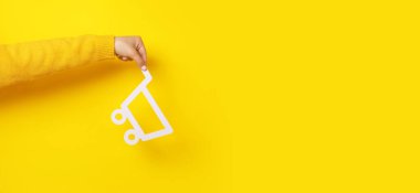 Sarı arka plandaki alışveriş arabası, tüketici konsepti, panoramik model