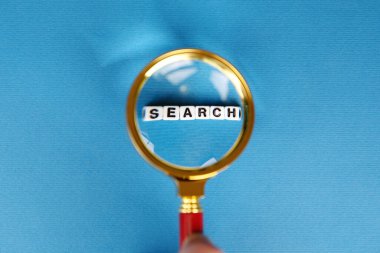 Moda mavisi arkaplanda büyüteçle arama sözcüğü