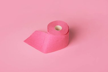 Pembe arka planda tuvalet kağıdı rulosu, kişisel hijyen malzemesi