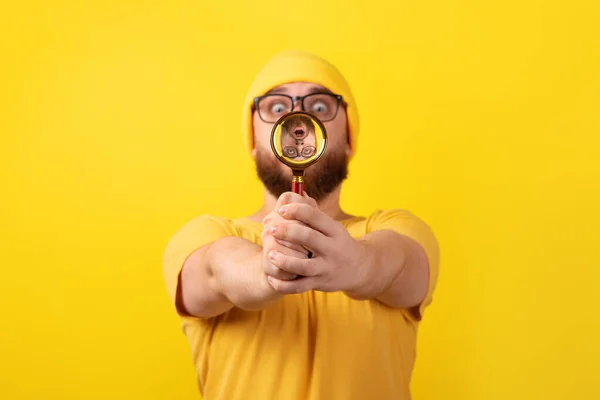 Geschokte Man Kijkend Door Vergrootglas Gele Achtergrond — Stockfoto