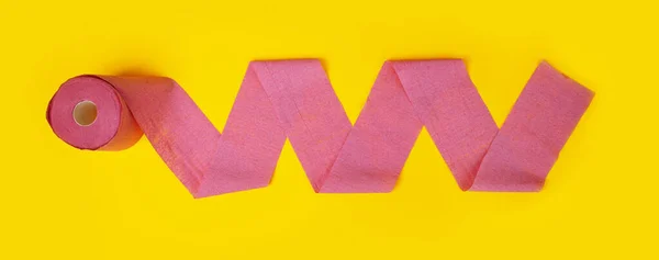 黄色の背景にピンクのトイレタリー紙のロール パノラマ画像 — ストック写真