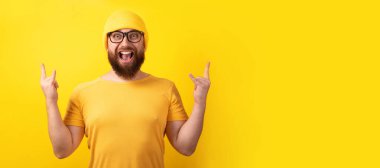 Adam sarı zemin üzerinde rock n roll hareketi yapıyor, panoramik düzen